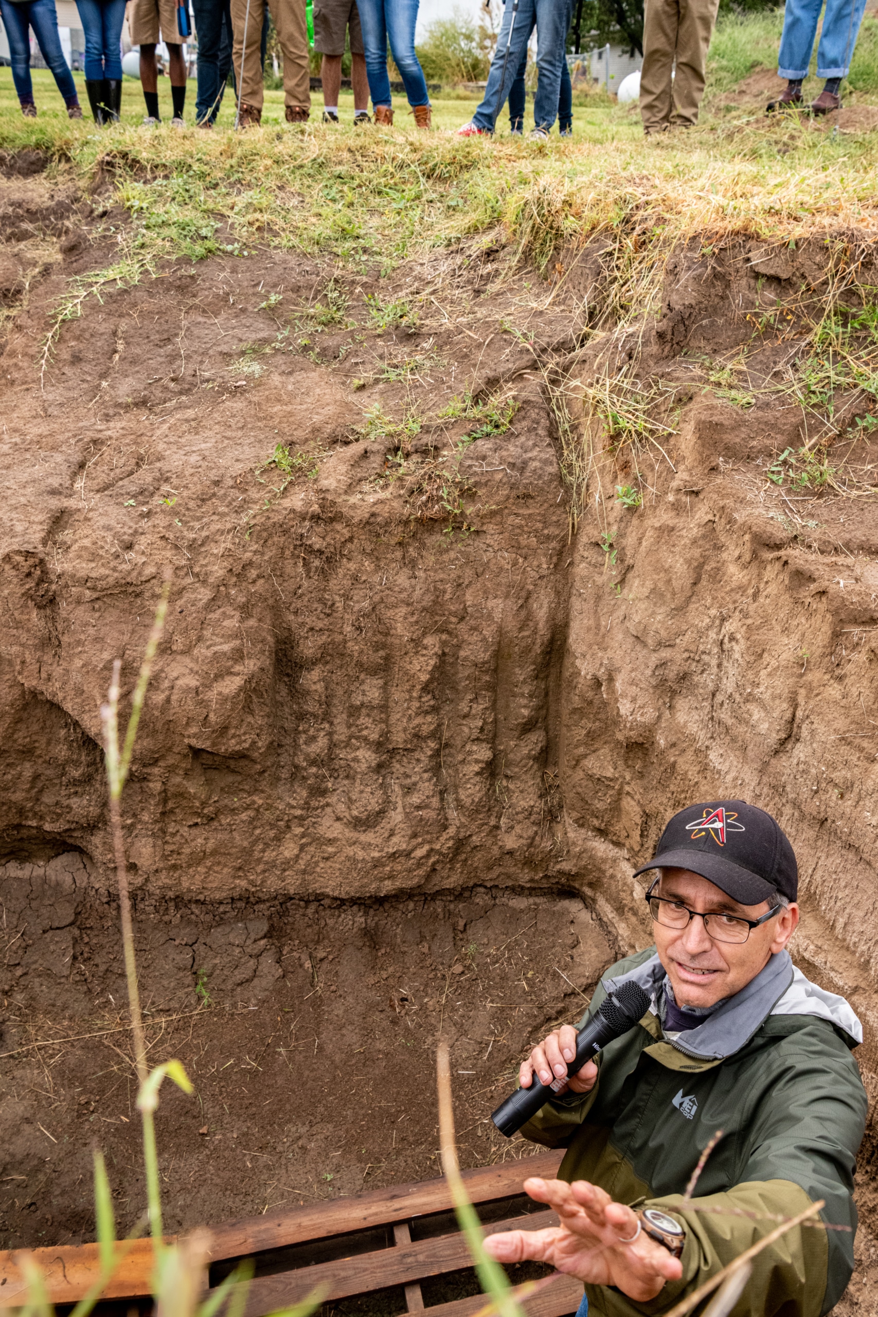 Working from a pit dug to expose plant roots, Tim Crews